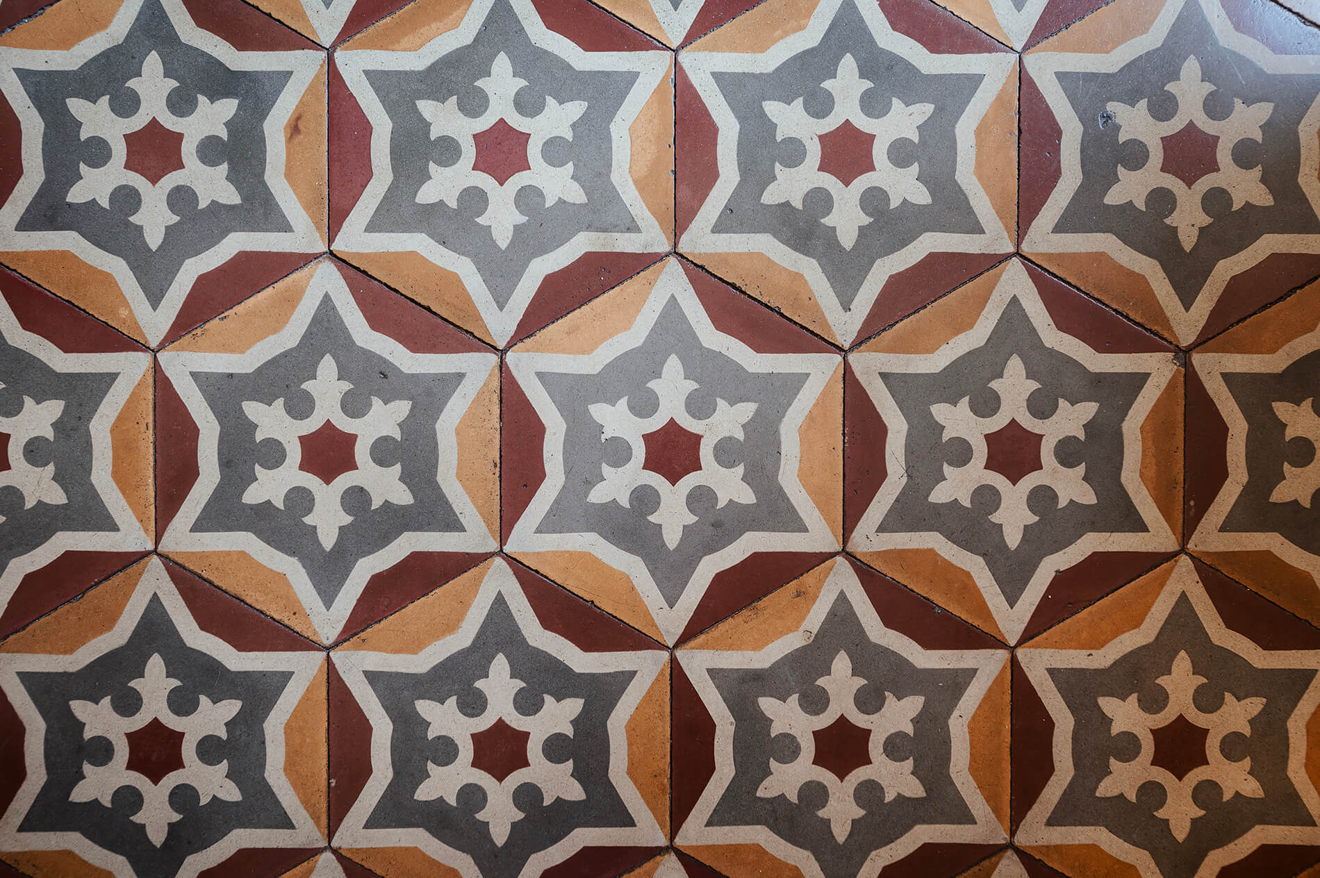 inloco lab architetto a Sassello - pavimento storico esagonale con decori rosso e ocra. Dettaglio della posa pavimento